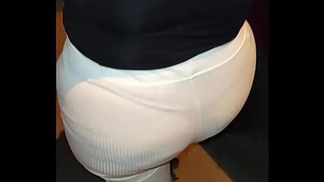 Curvaceous lady adorned with red thread &mdash;  sizzling under see-through pants on the sidewalk